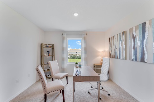 Multi-purpose office space with desk, seating and windows for natural lighting.