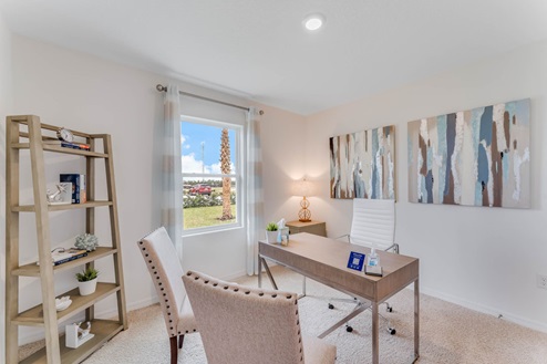 Multi-purpose office space with desk, seating and windows for natural lighting.