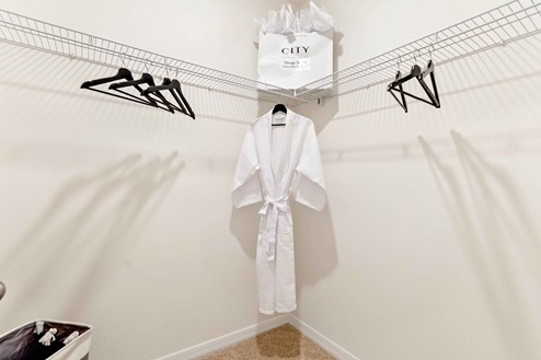 Spacious walk-in closet with robe on hanger.