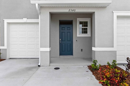 Entrance to two-story townhome with one-car garage.