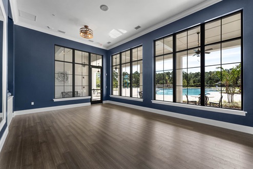 Fitness center studio overseeing pool through window.