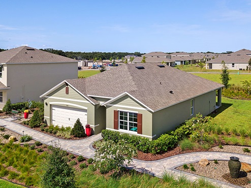 Single story new home with siding, covered porch and 2 car garage.