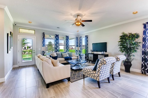 Open concept living area with couch seating with access to the backyard through door.