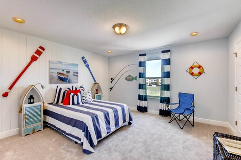 Spare bedroom for guests, with bed, dresser and natural lighting.