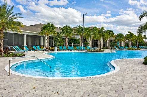 Sunny day at the community swimming pool with lounge seating.