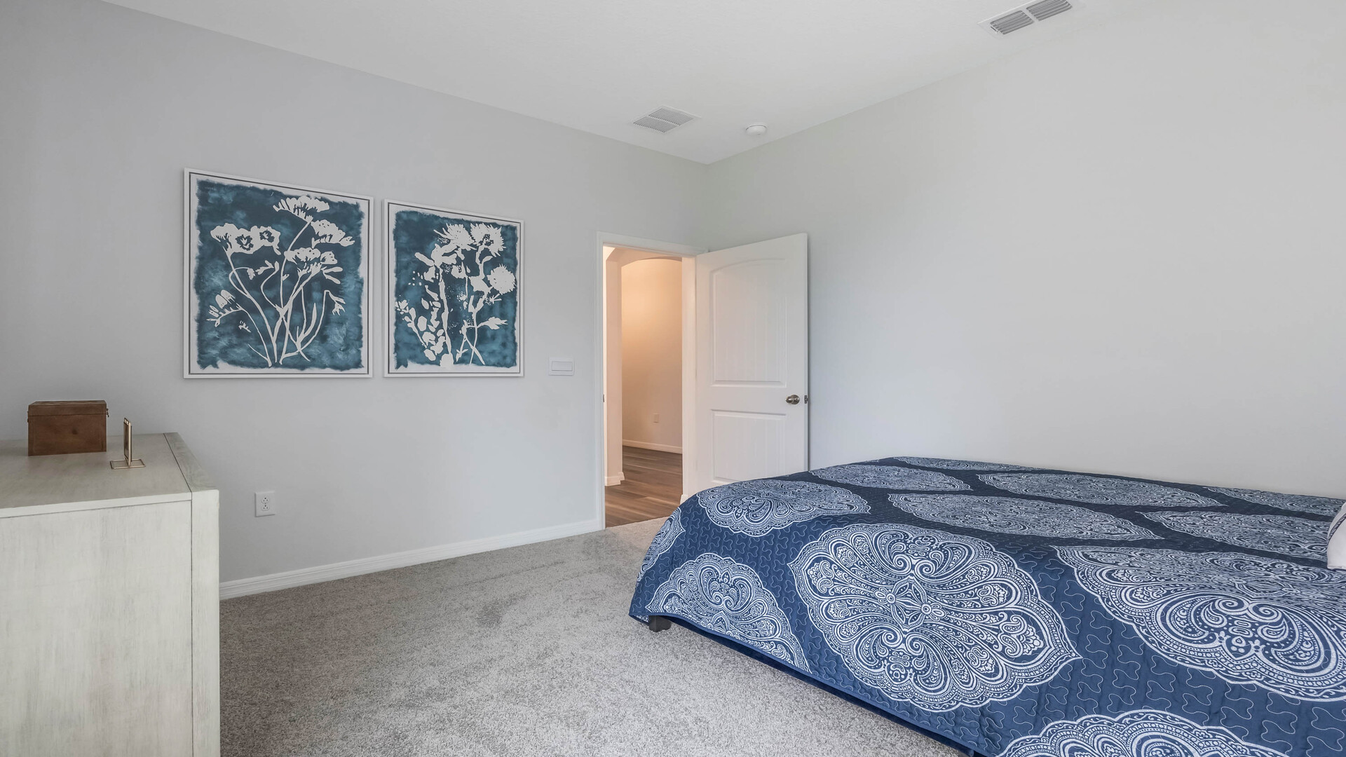 Guest bedroom with bed, nighstand, desk, and natural lighting with spacious closet.