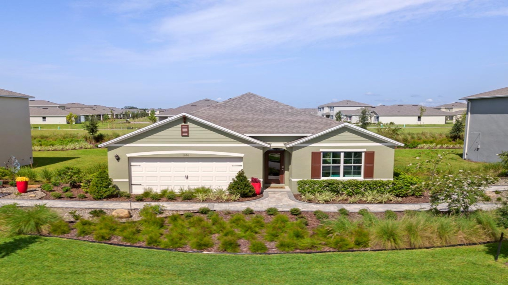 Single story new home with siding, covered porch and 2 car garage.