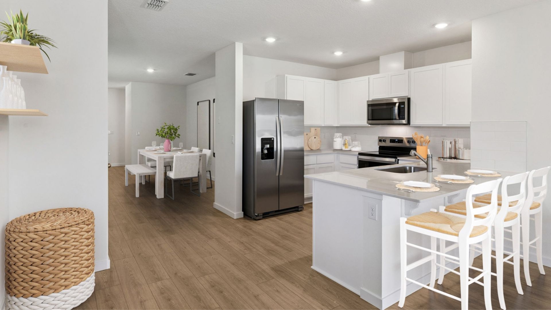 Kitchen with seating, quartz counters, spacious pantry and stainless steel appliances overseeing dining room