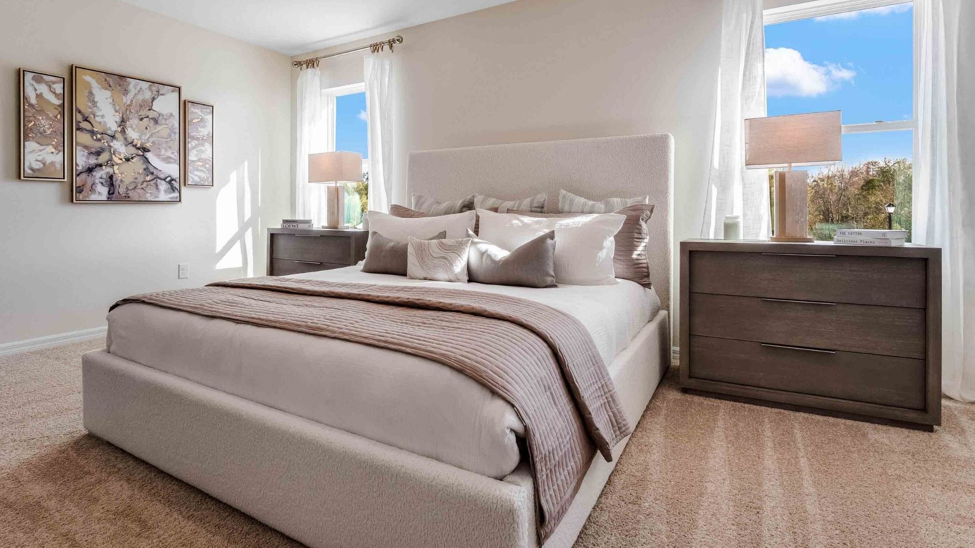 Spacious primary bedroom with king size bed, carpet flooring, natural lighting.