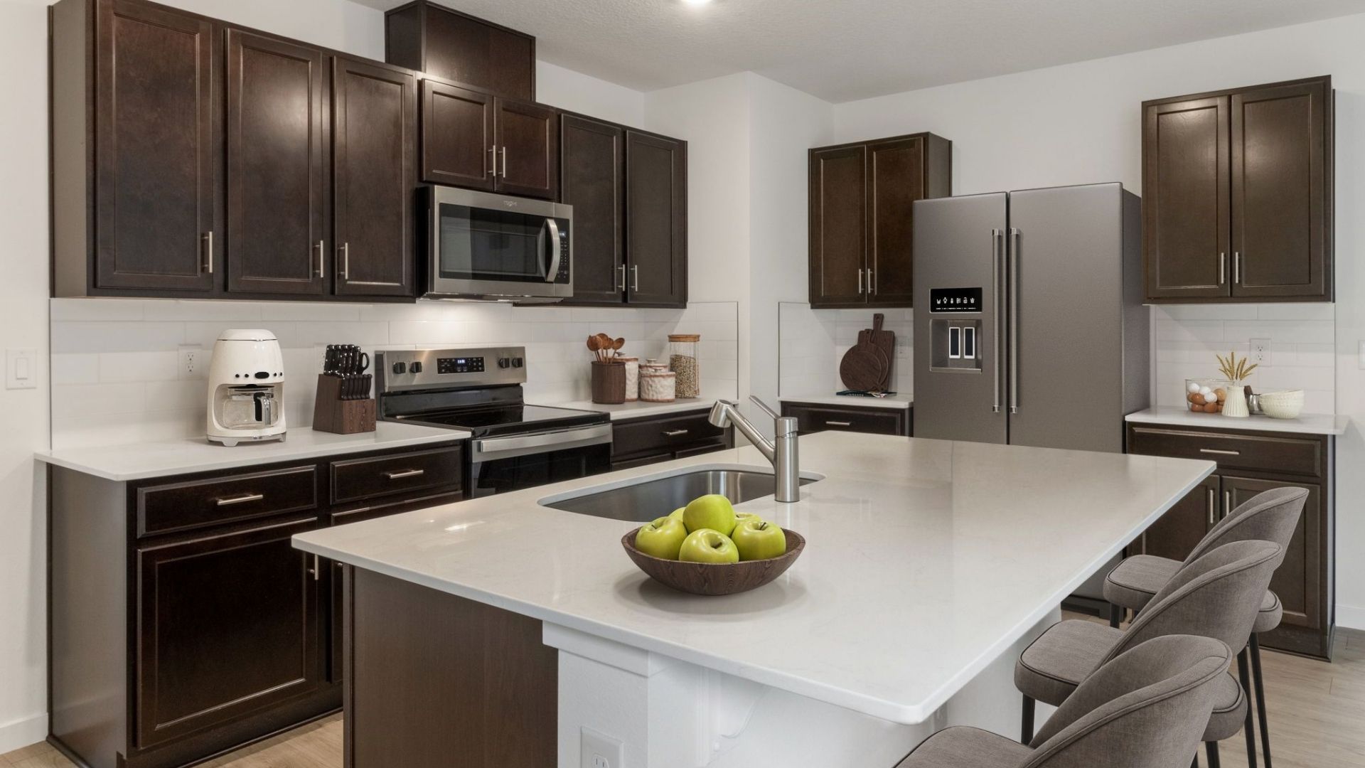 Kitchen with island seating, quartz counters, spacious pantry and stainless steel appliances