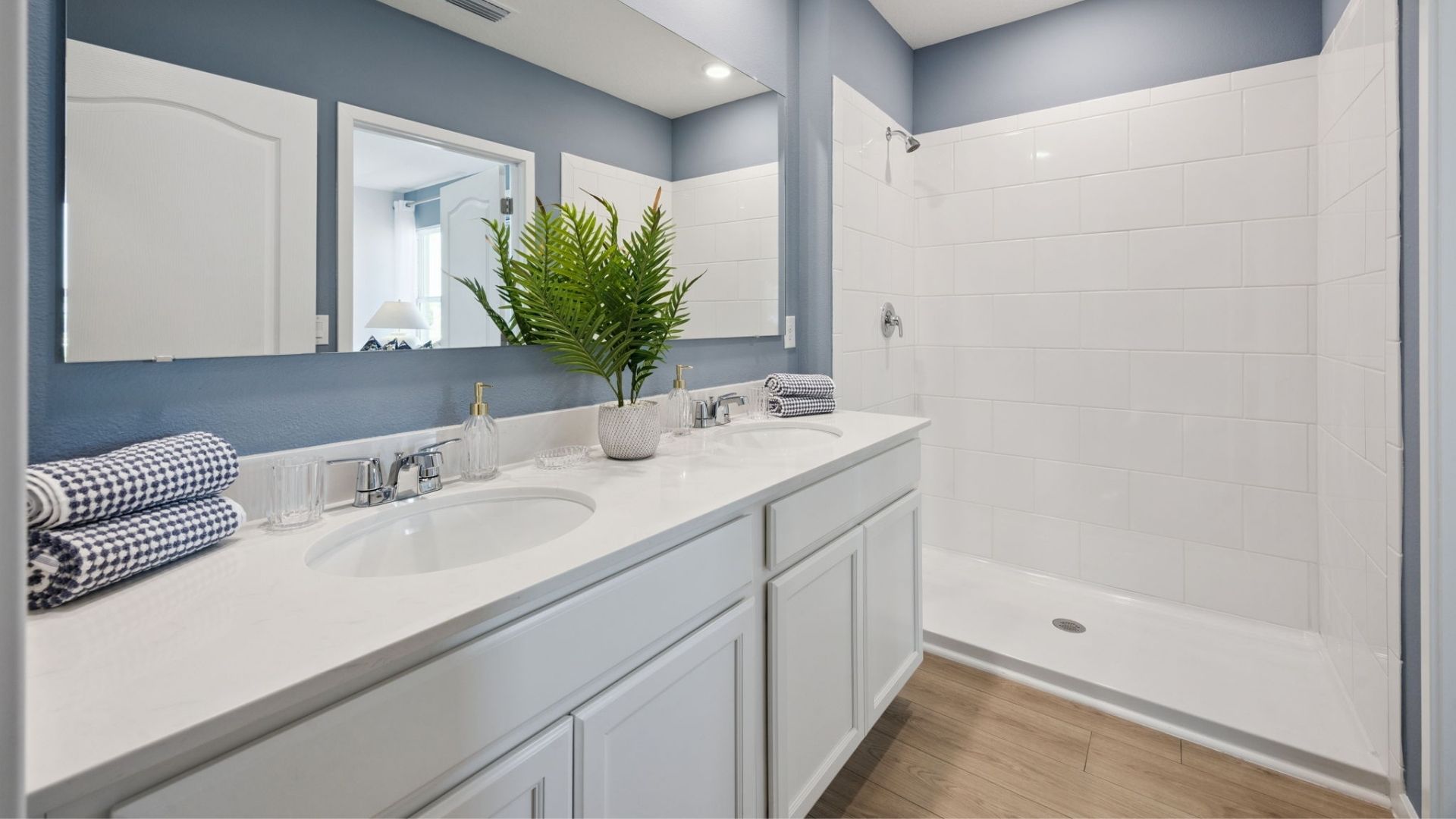 primary bathroom with quartz counters double sink and revwood select flooring