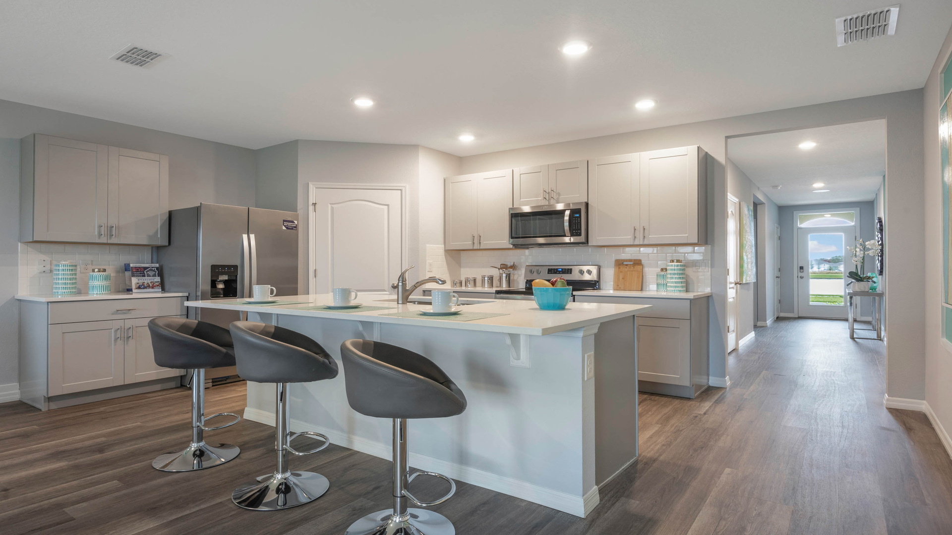 Kitchen with tall cabinetry, appliances, walk in pantry and Luxury vinyl plank flooring.