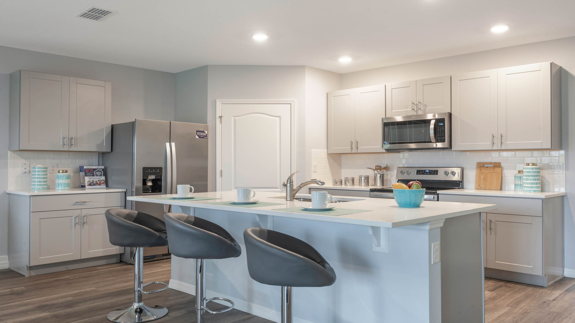 Kitchen with tall cabinetry, appliances, walk in pantry and Luxury vinyl plank flooring.