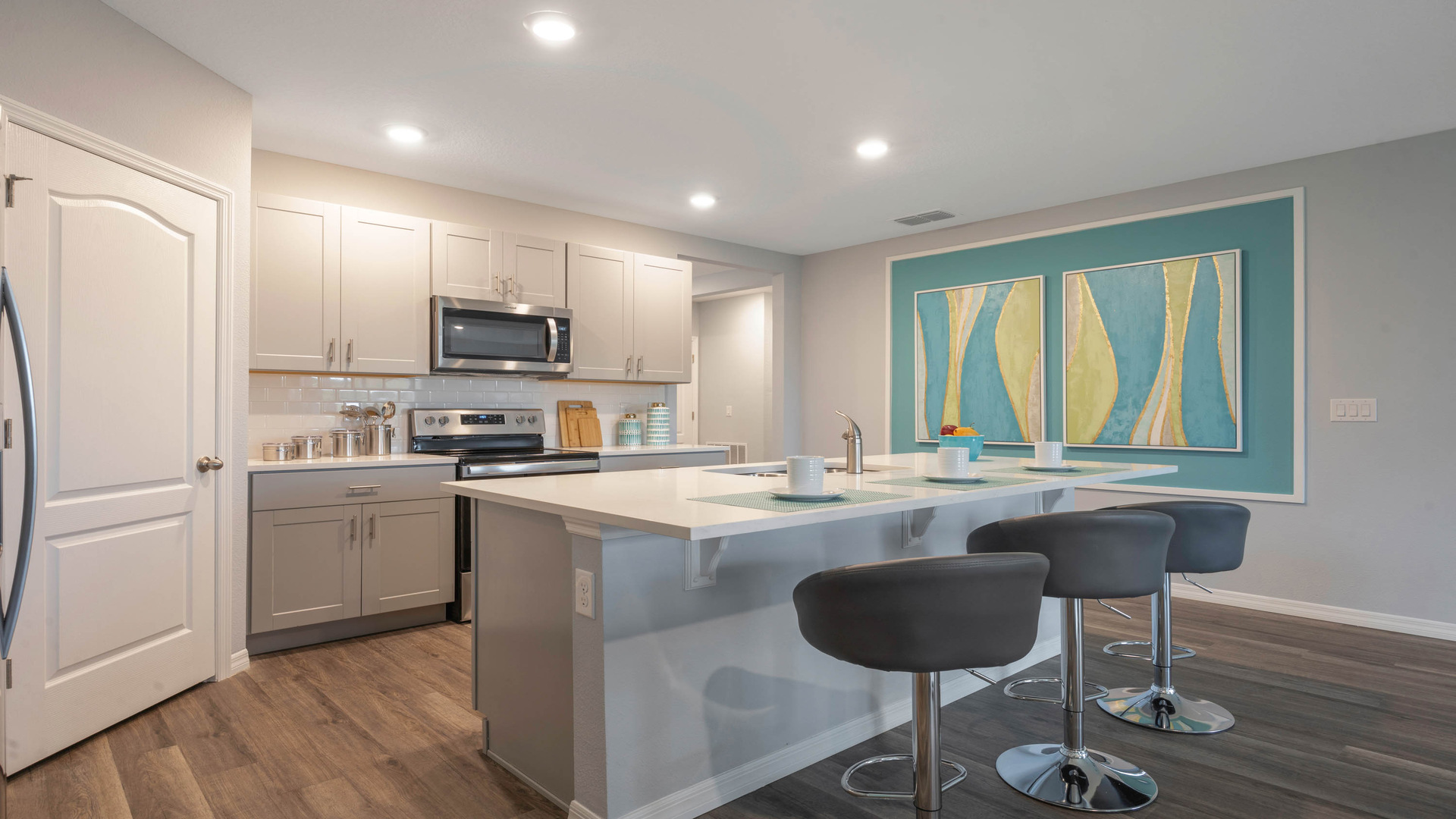 Kitchen with tall cabinetry, appliances, walk in pantry and Luxury vinyl plank flooring.