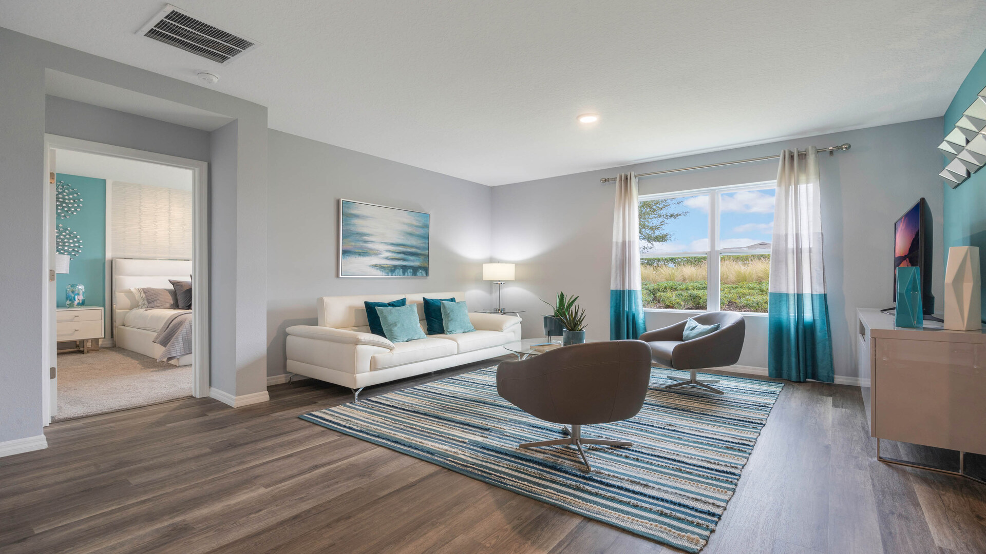 Living area with couch seating and natural lighting next to access to Master Bedroom.