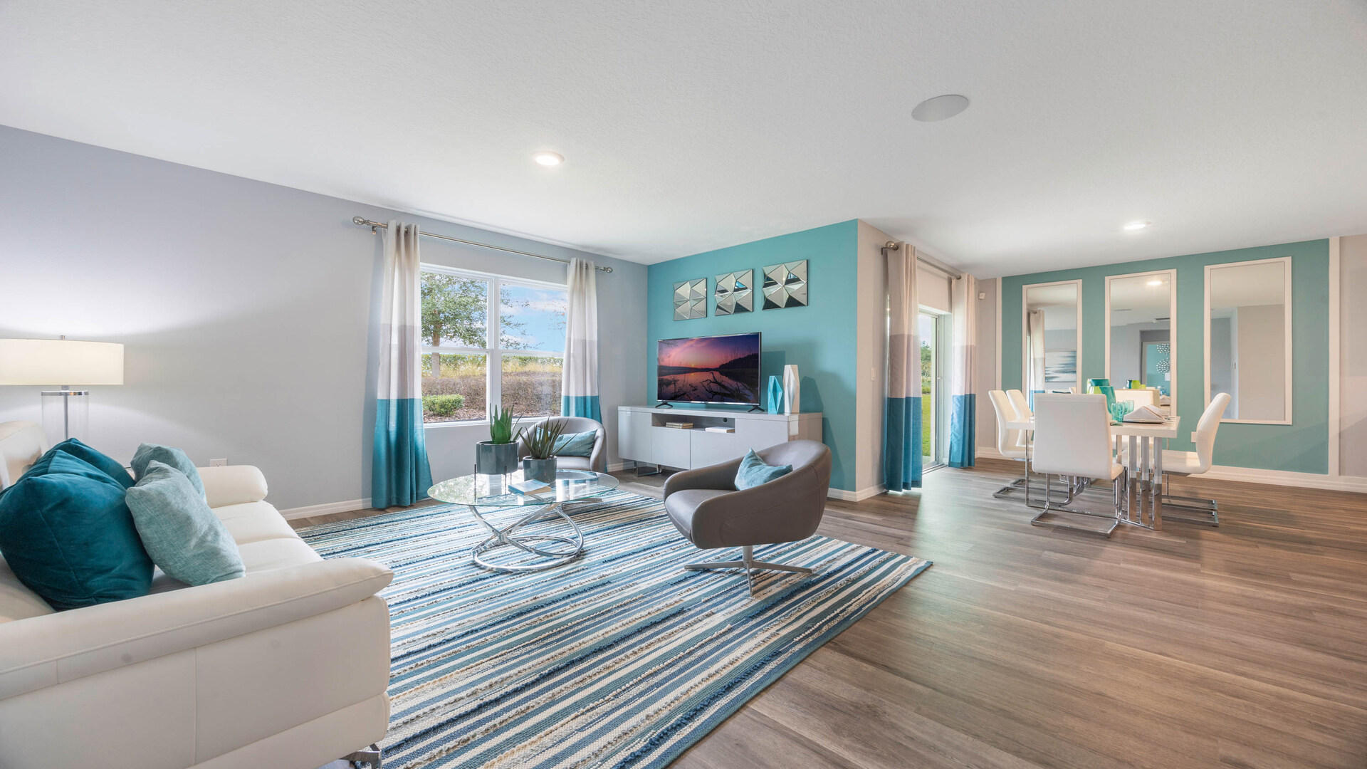 Living area with couch seating, entertainment system and natural lighting.