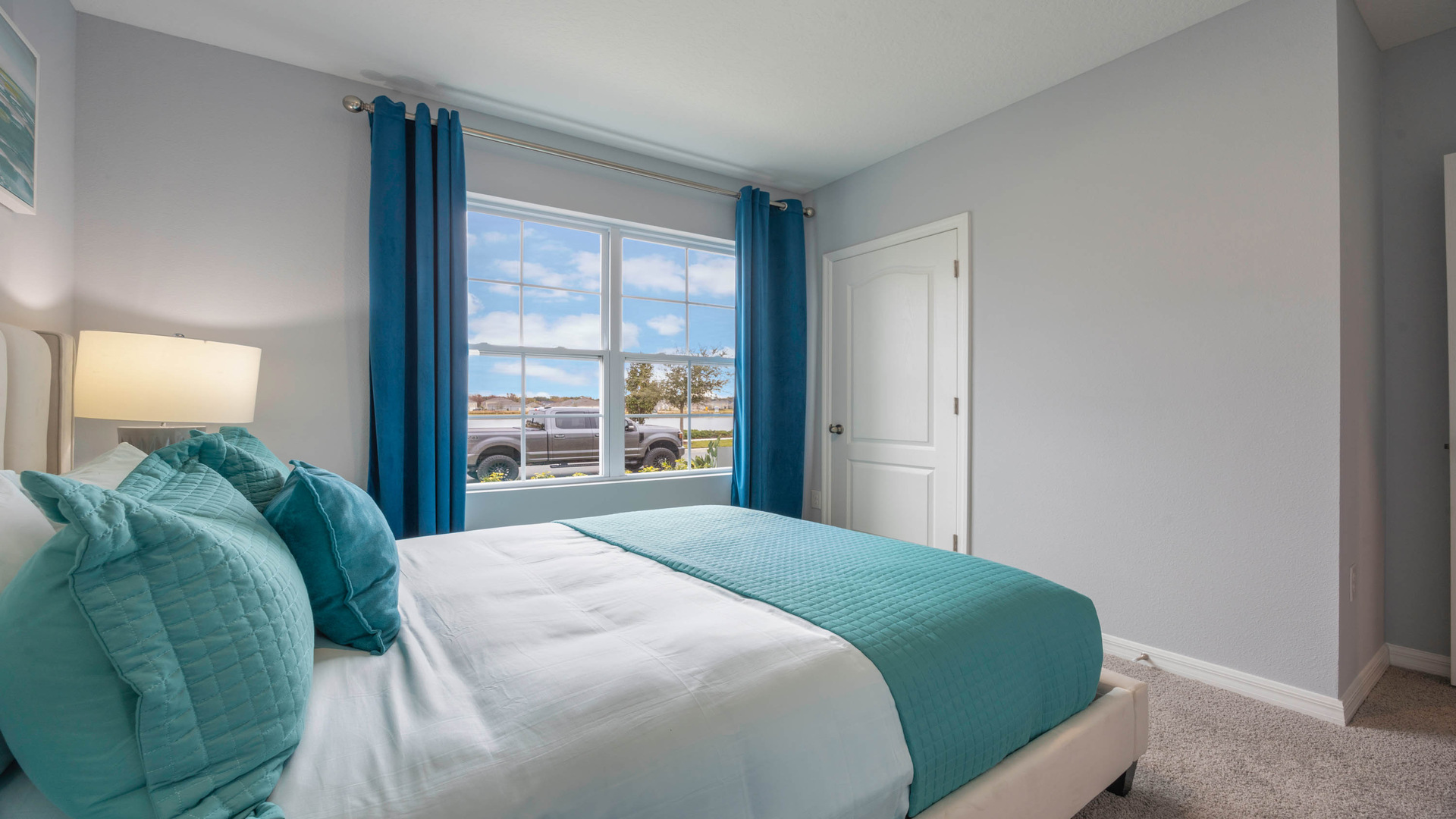 Guest bedroom with bed, nighstands and natural lighting.