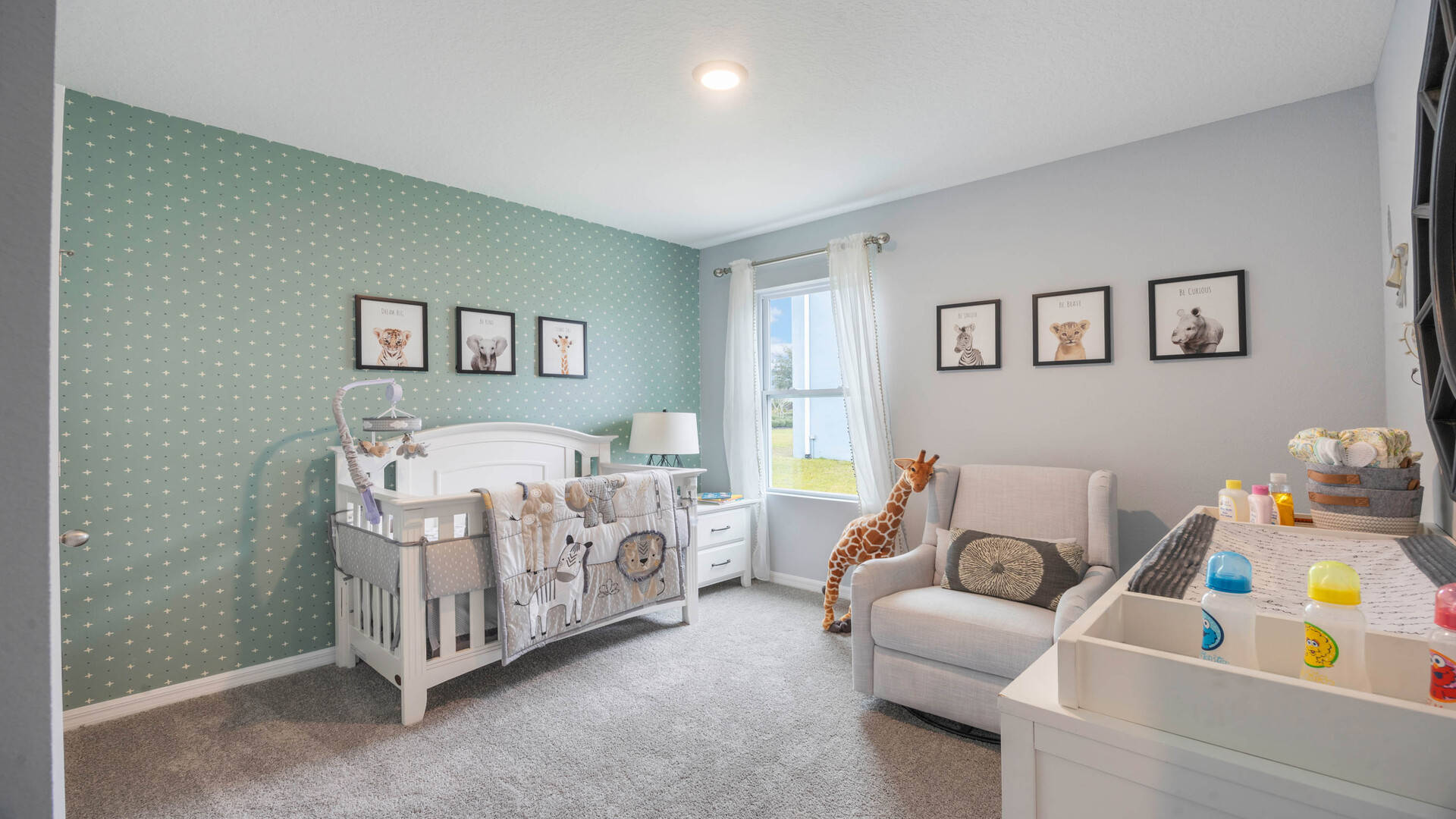 Child's nursery with crib, closet, soft seating and storage.