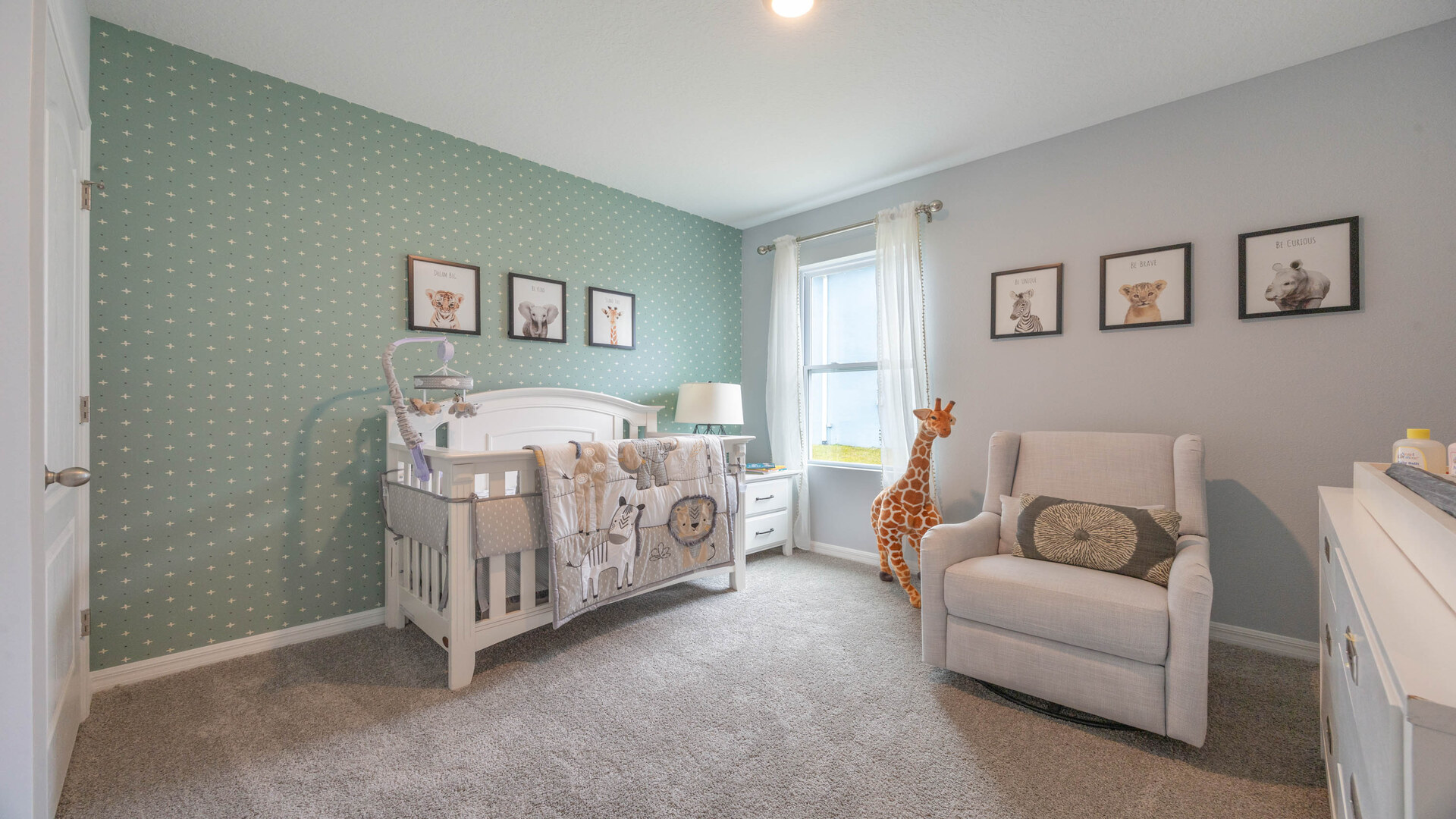 Child's nursery with crib, closet, soft seating and storage.