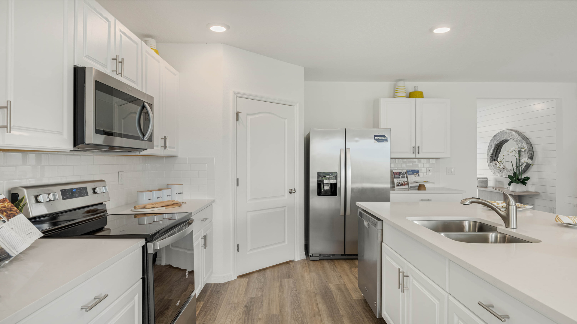 Kitchen with island seating, quartz counters, spacious pantry and stainless-steel appliances.