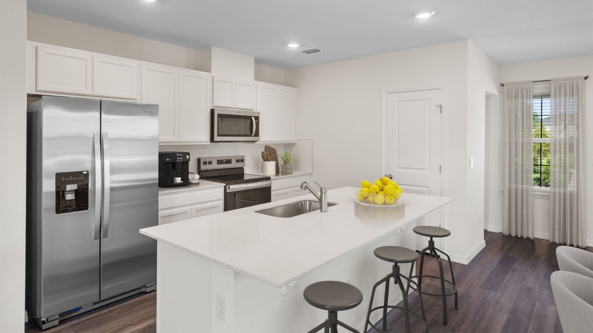 Kitchen with island seating, quartz counters, spacious pantry and stainless steel appliances