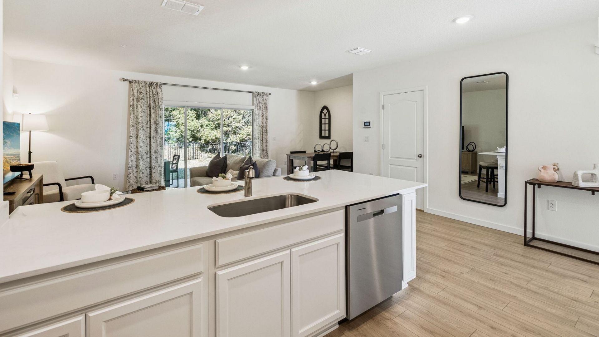 kitchen with quartz countertops overseeing living area and dining room table