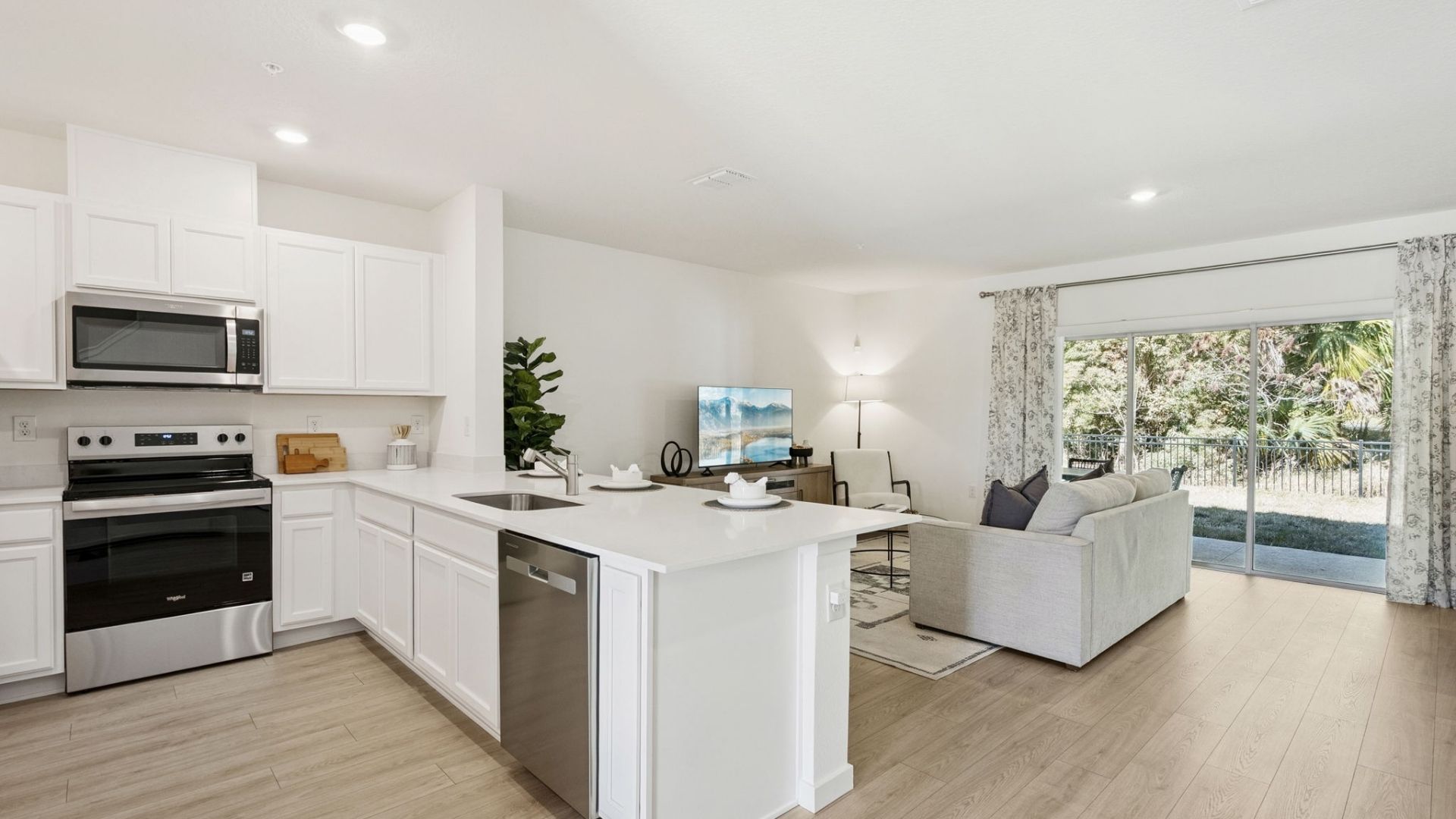 kitchen with quartz countertops overseeing living area and dining room table