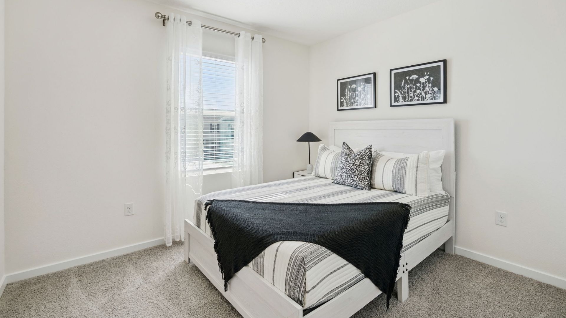 Guest bedroom with bed, nighstands and natural lighting.