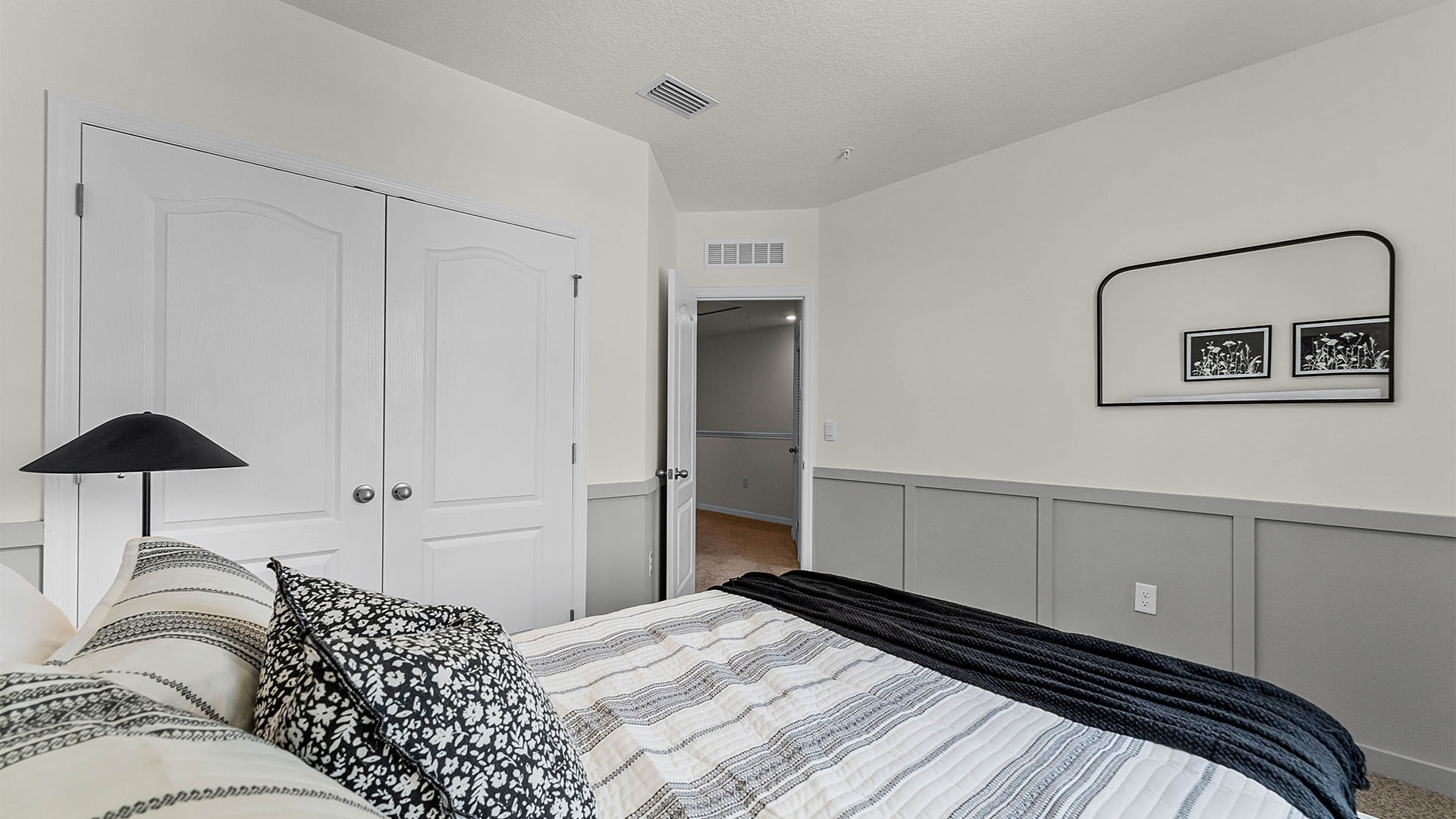 Guest bedroom with bed, nighstands and natural lighting.