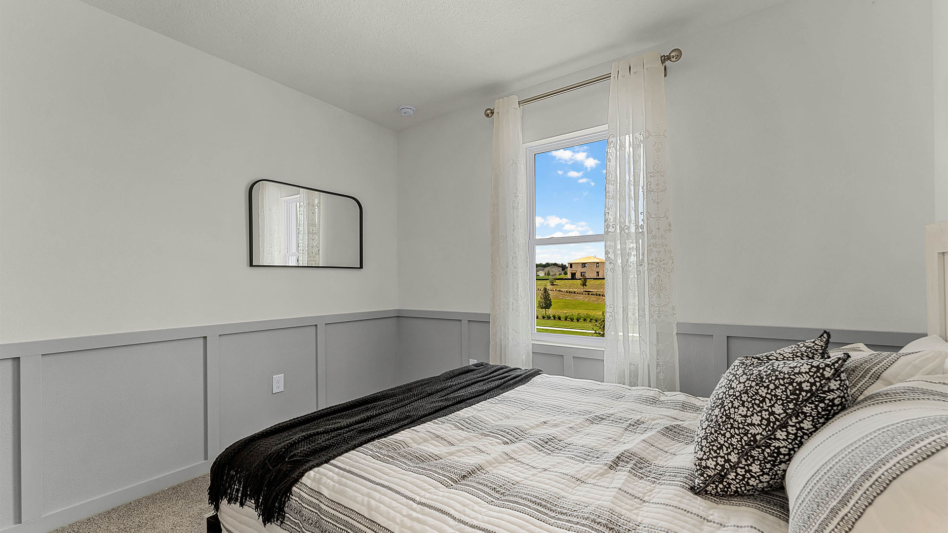 Guest bedroom with bed, nighstands and natural lighting.