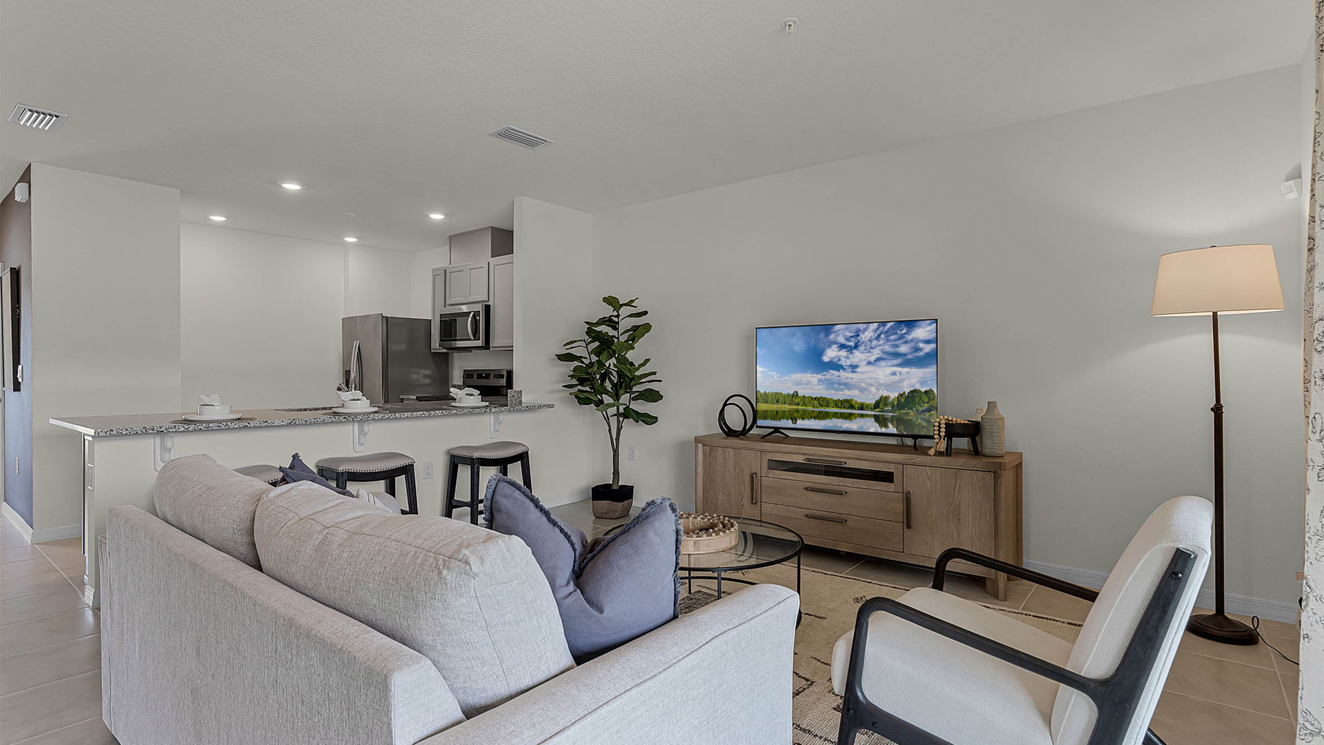 Living area with couch seating overseeing kitchen.