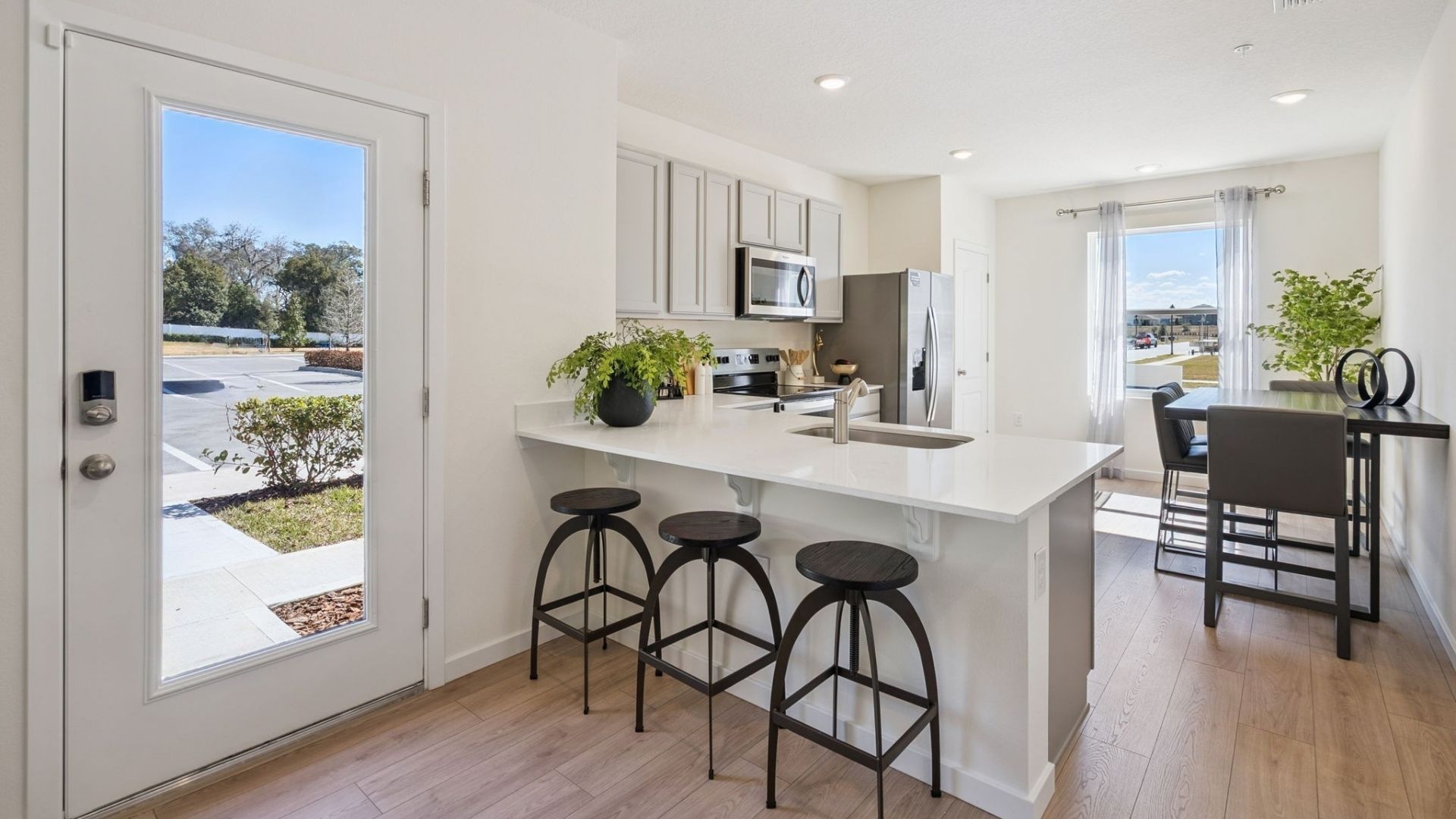 kitchen with quartz countertops overseeing living area and dining room table