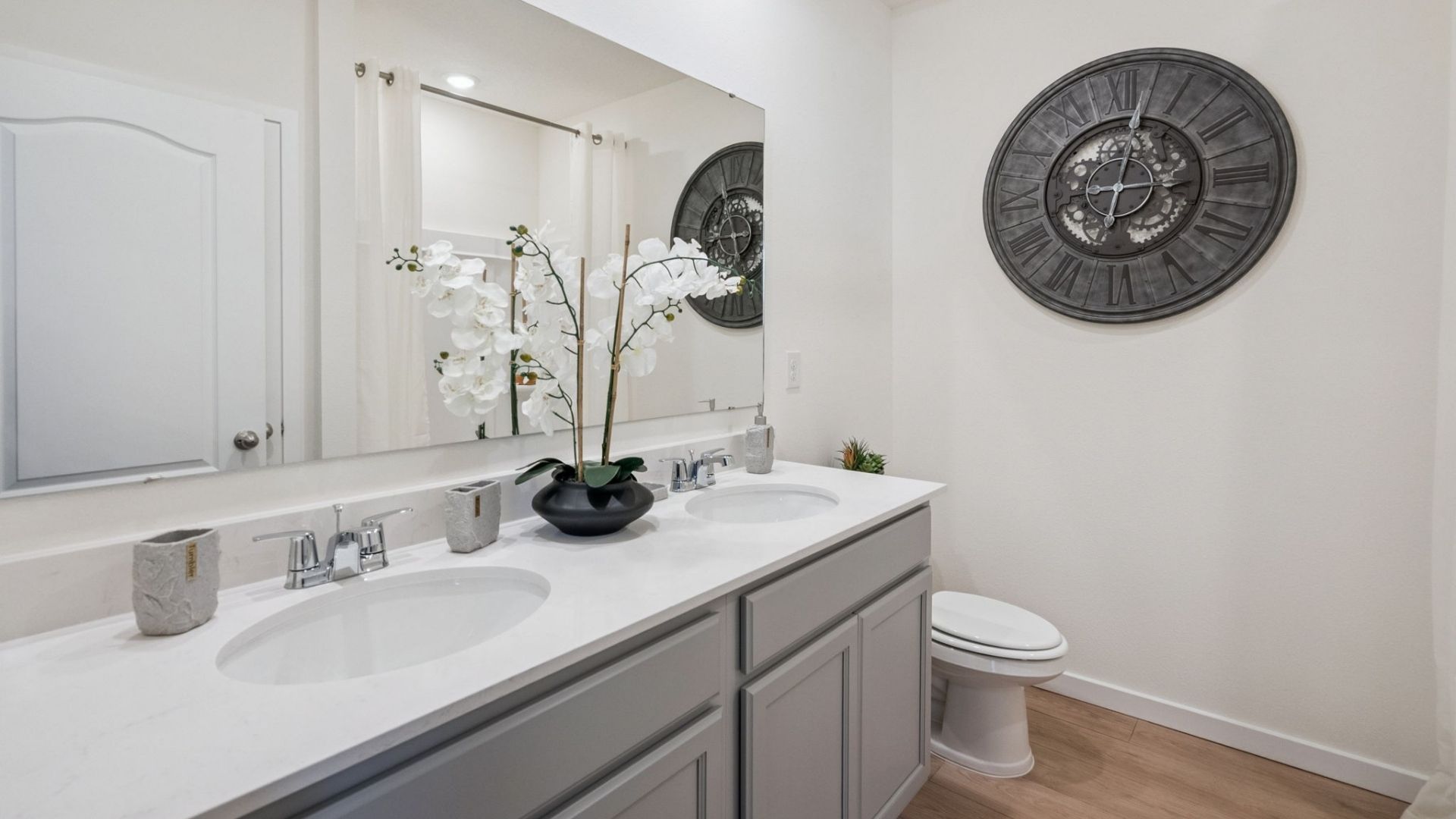 primary bathroom with quartz counters double sink and revwood select flooring