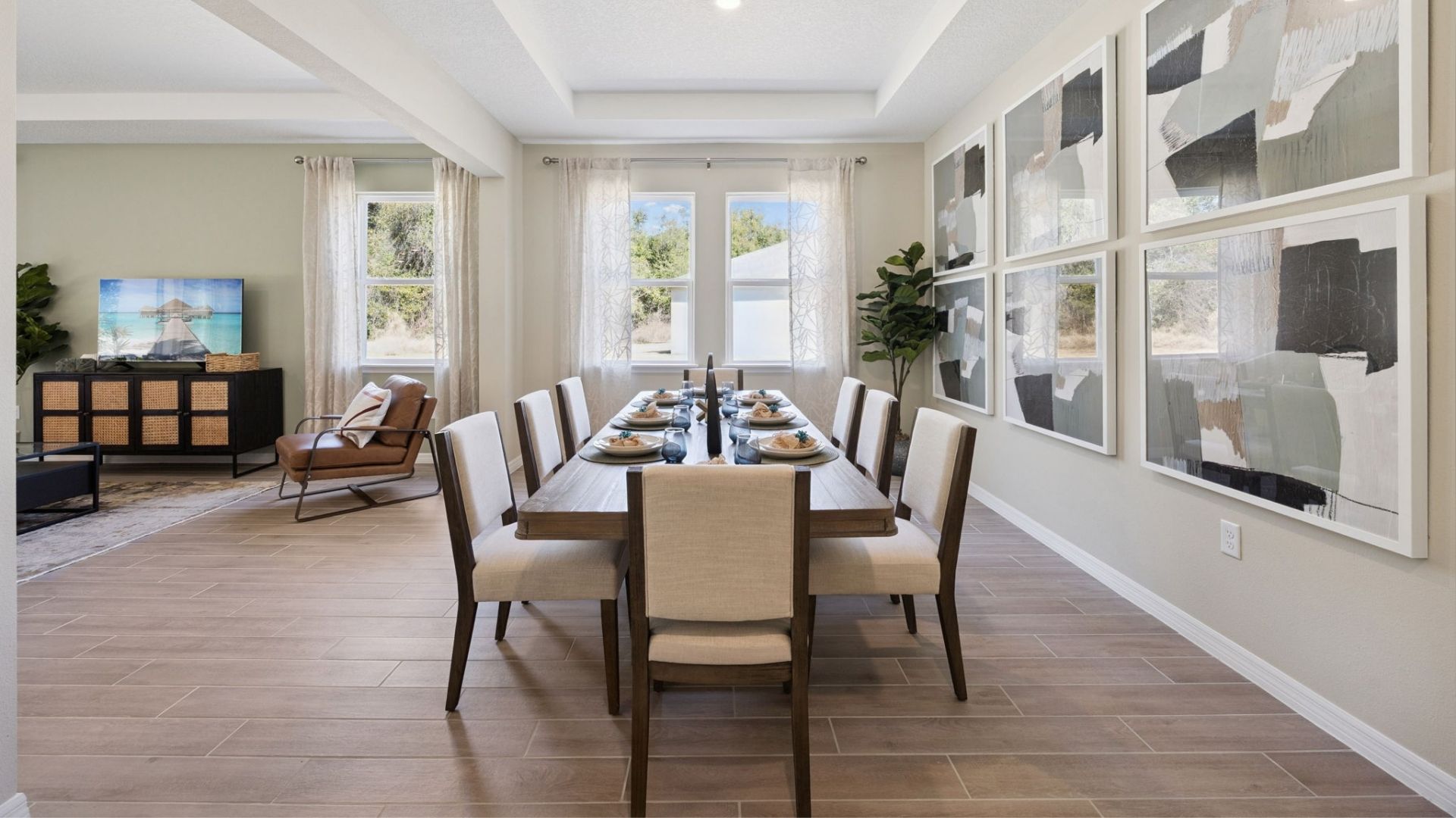 living area with couch seating and entertainment system overseeing kitchen and dining room table.