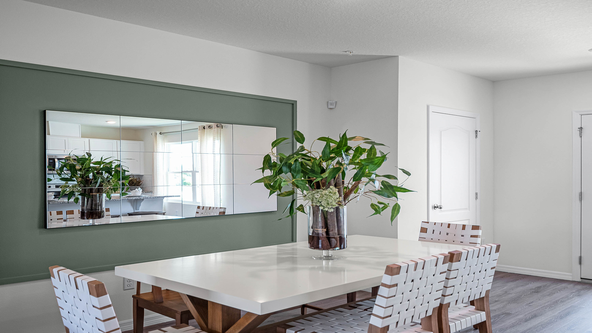 Dining room table with seating and wooded flooring.
