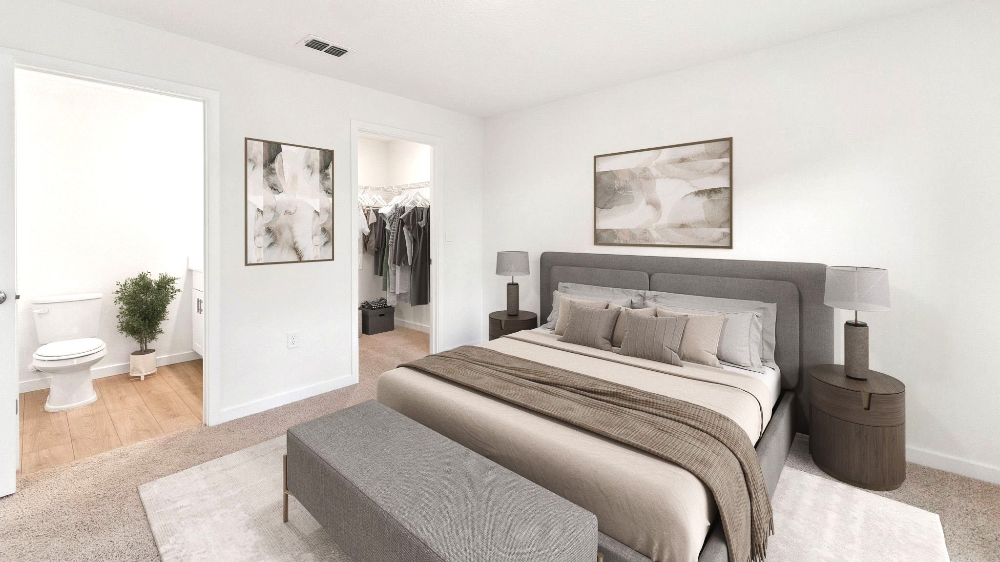 Spacious primary bedroom with king size bed, carpet flooring, natural lighting.