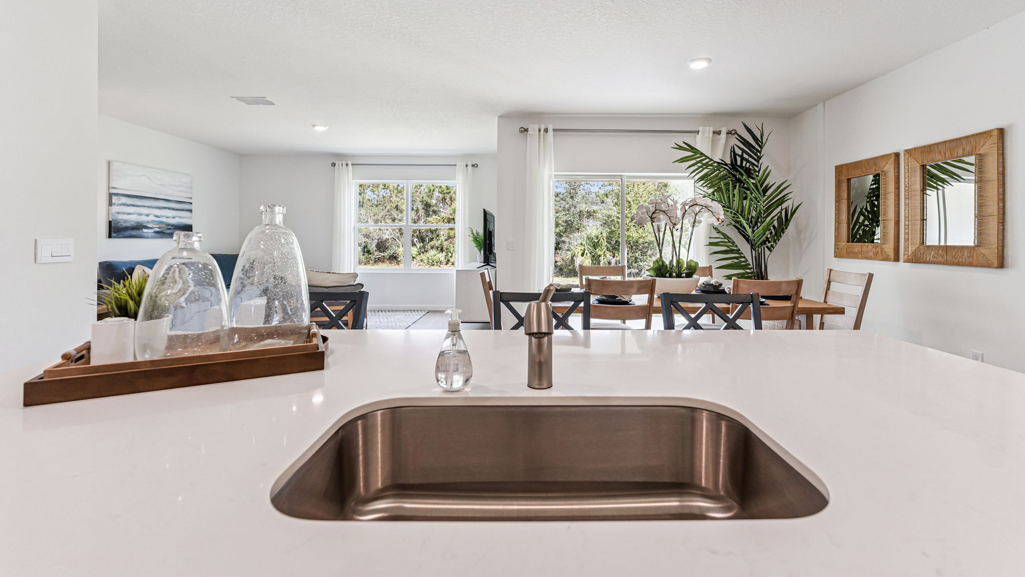 Kitchen with island seating, quartz counters, spacious pantry and stainless steel appliances.