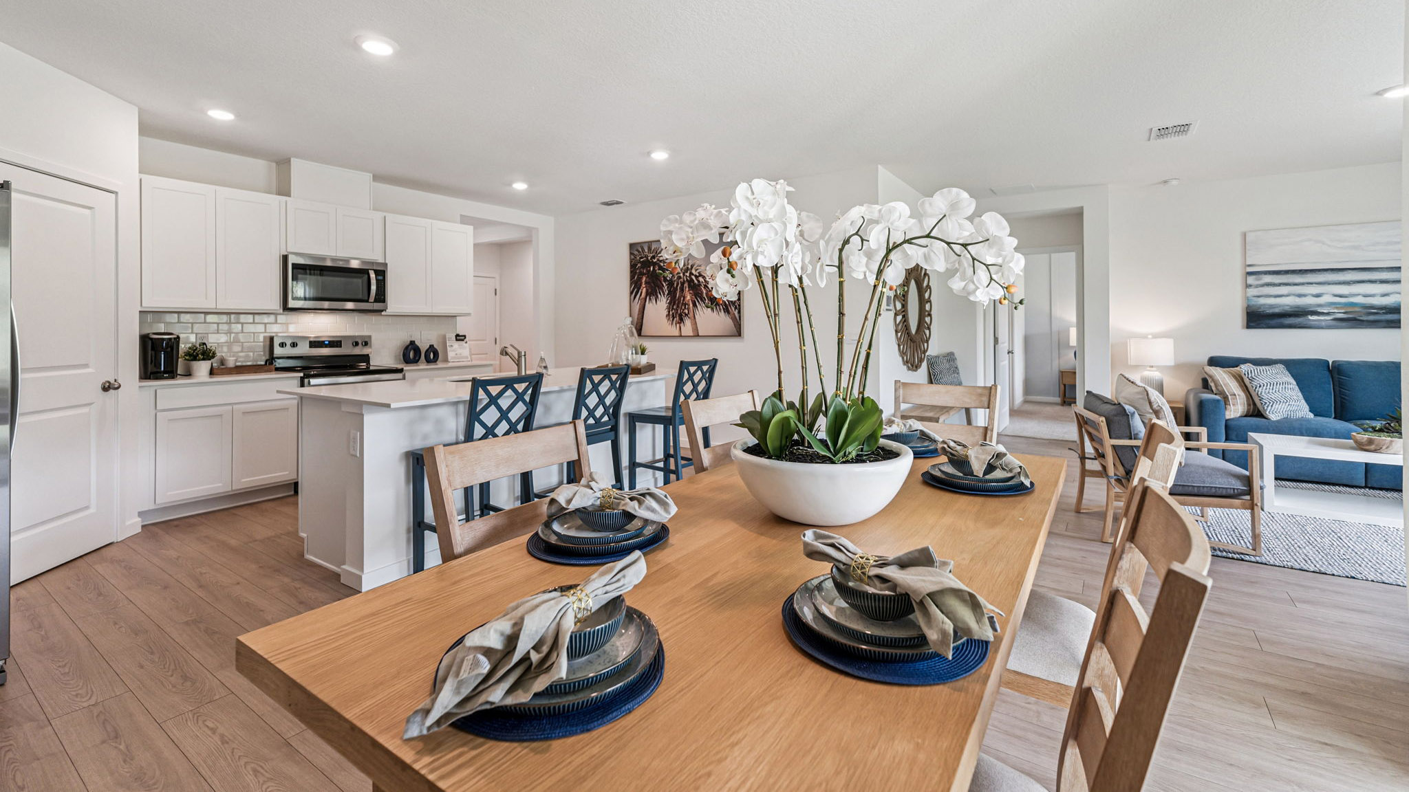 Kitchen with island seating, quartz counters, spacious pantry and stainless steel appliances.
