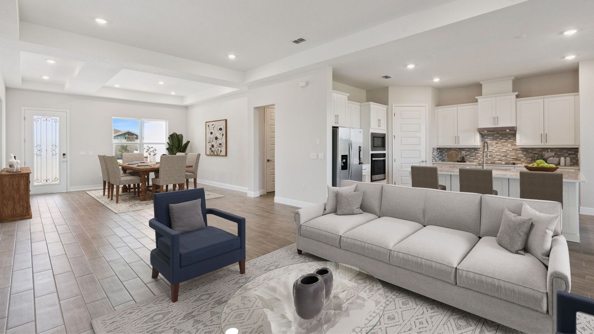 Living area with couch seating overseeing kitchen and dining room with laminate flooring.