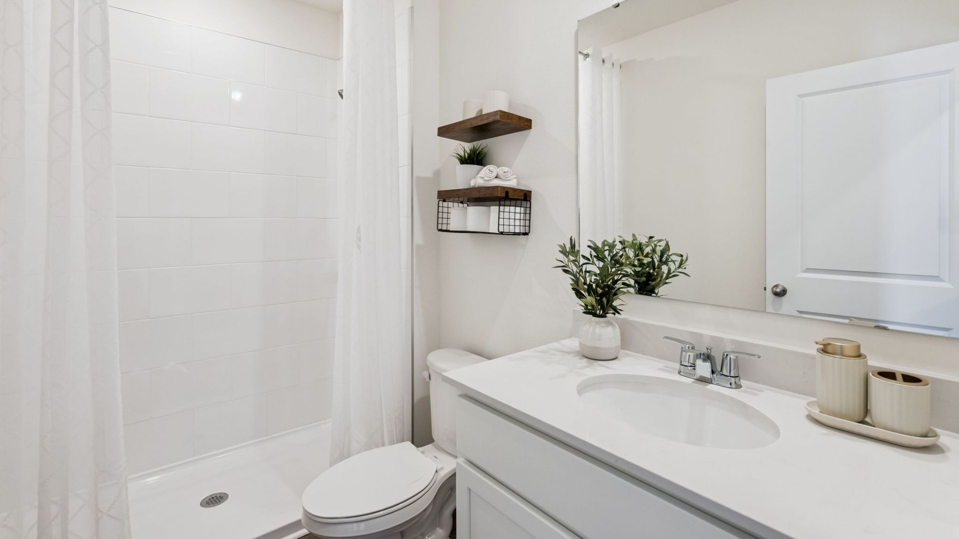Modern bathroom with single vanity, large wall mirror, cabinets and quartz countertops and laminate flooring
