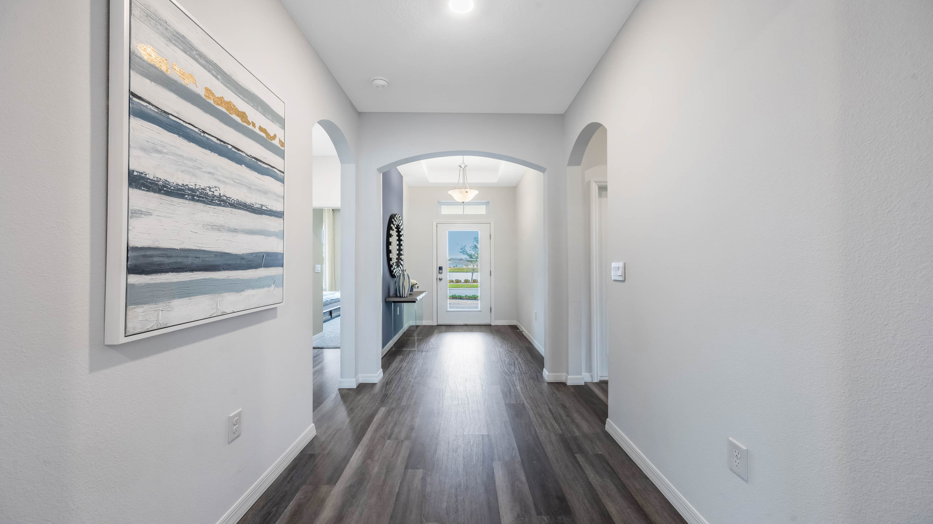Entry way with laminate flooring showing hallway to rooms.