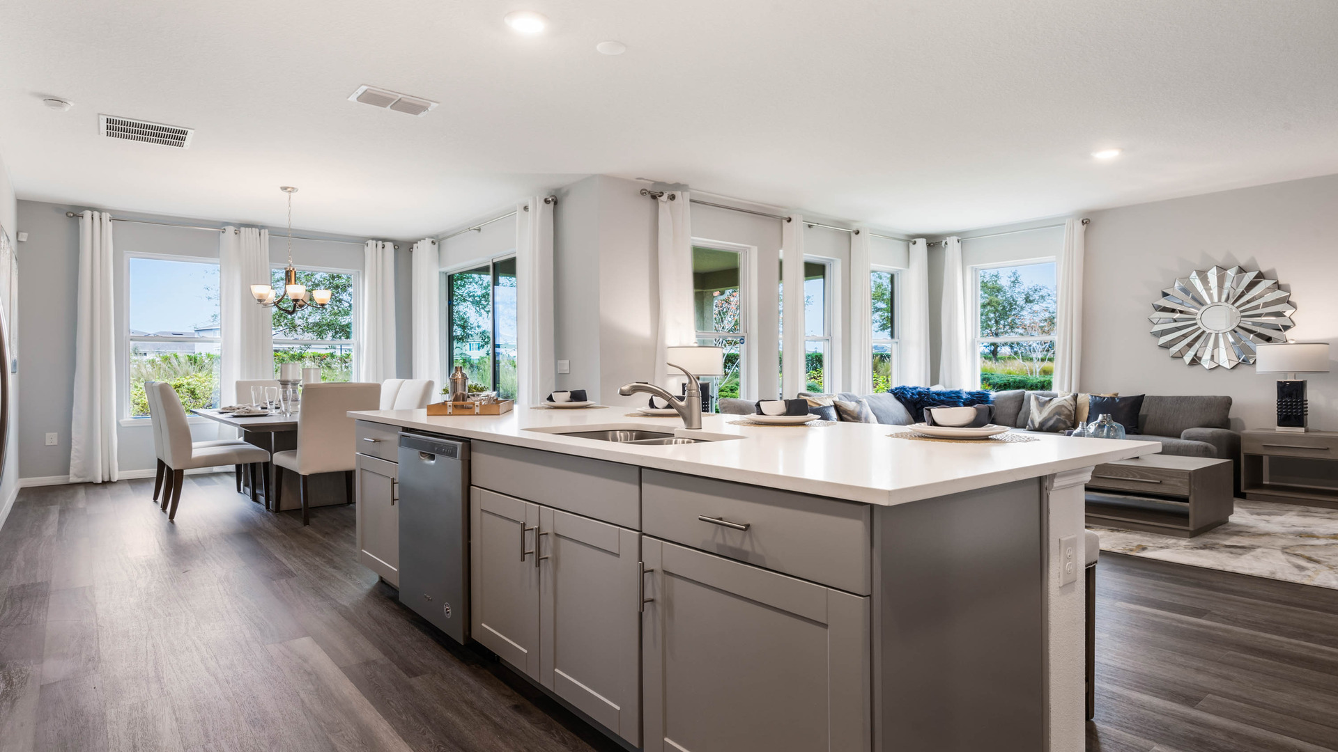 Kitchen with island seating, quartz counters, spacious pantry and stainless steel appliances showing entry way to home overseeing dining room