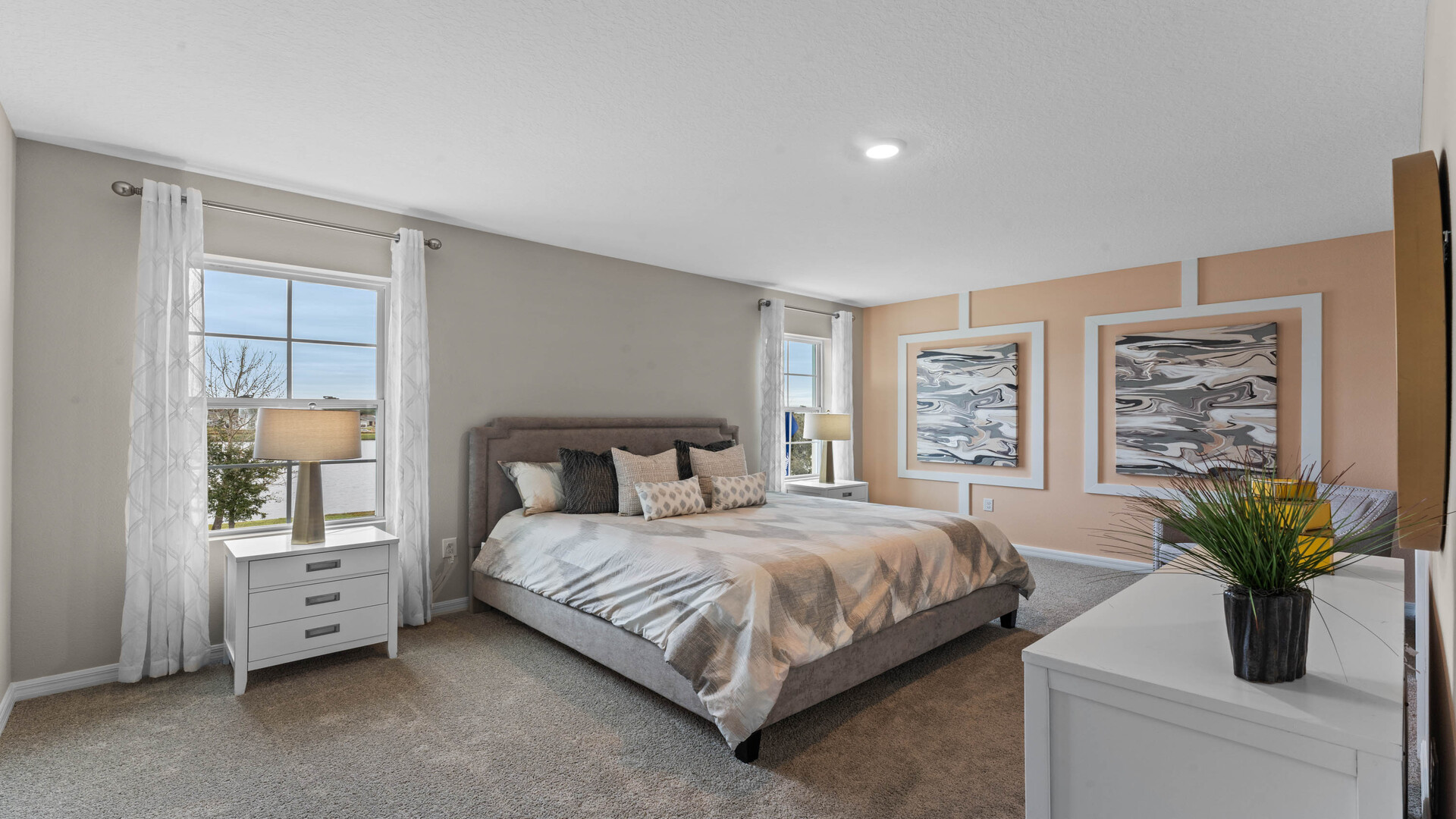 Kitchen with island seating, quartz counters, spacious pantry and stainless steel appliances.