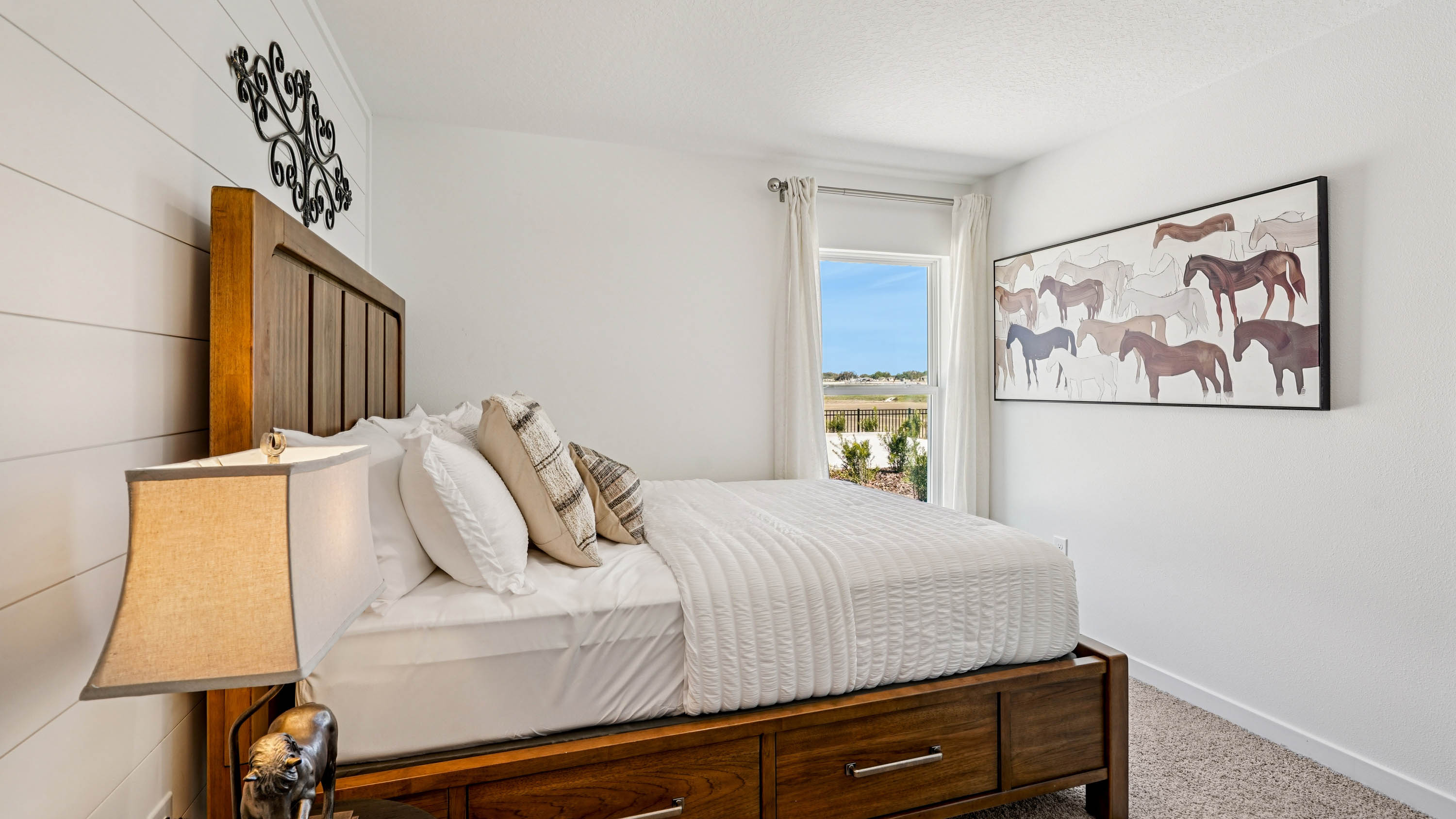 Guest bedroom with bed, nighstands and natural lighting.