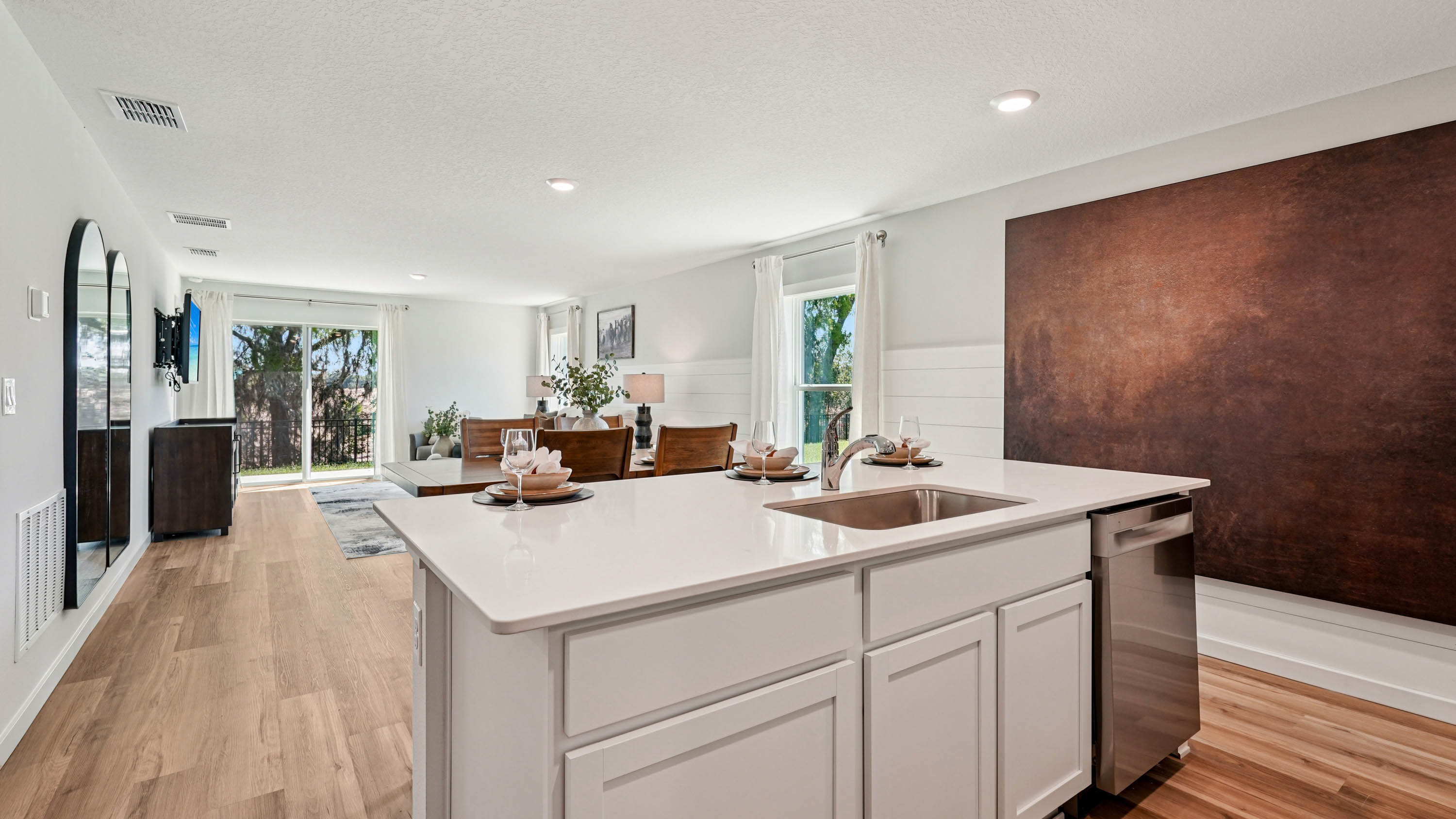 Kitchen with seating, quartz counters, spacious pantry and stainless steel appliances.