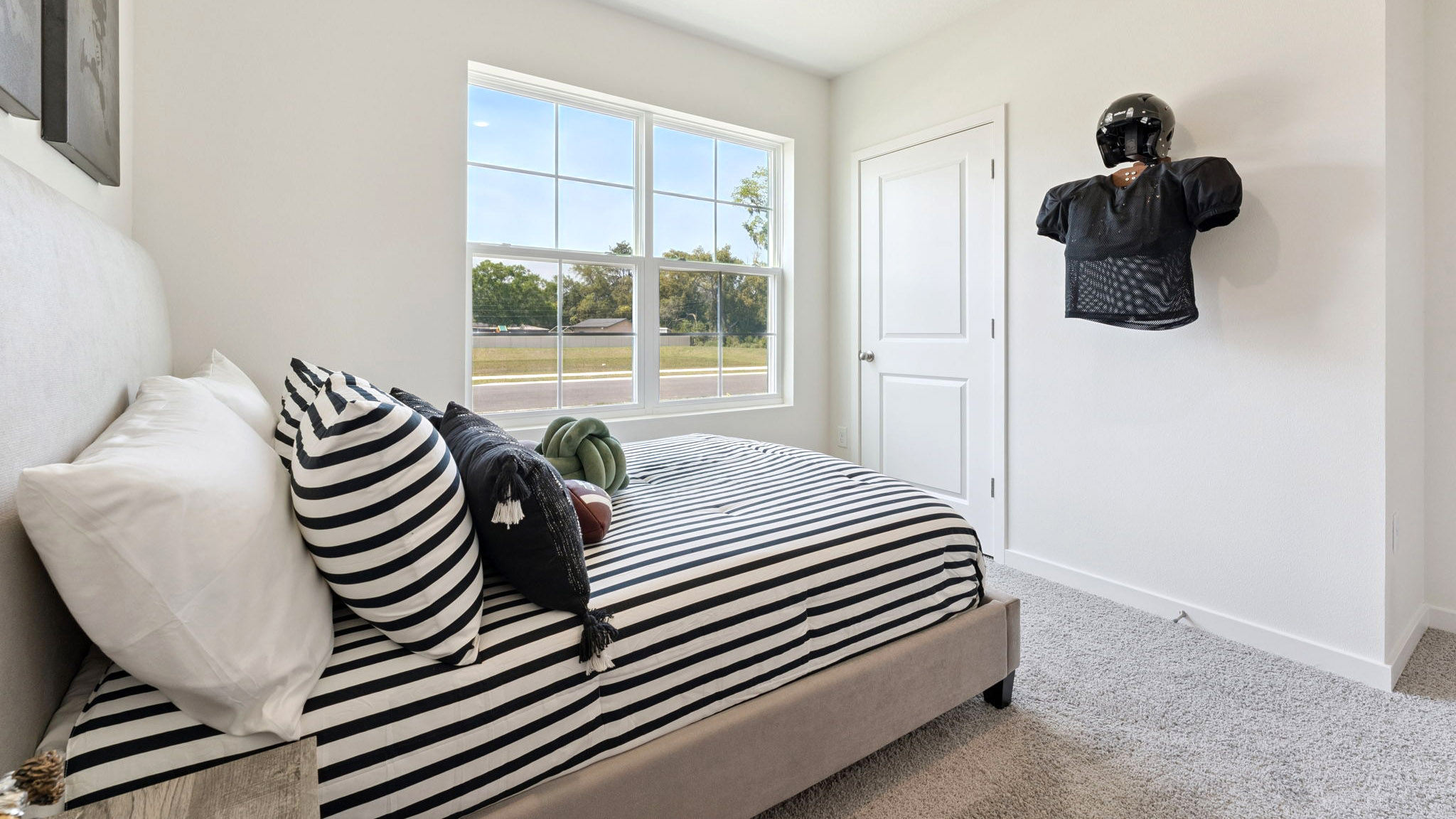Guest bedroom with bed, nighstands and natural lighting.
