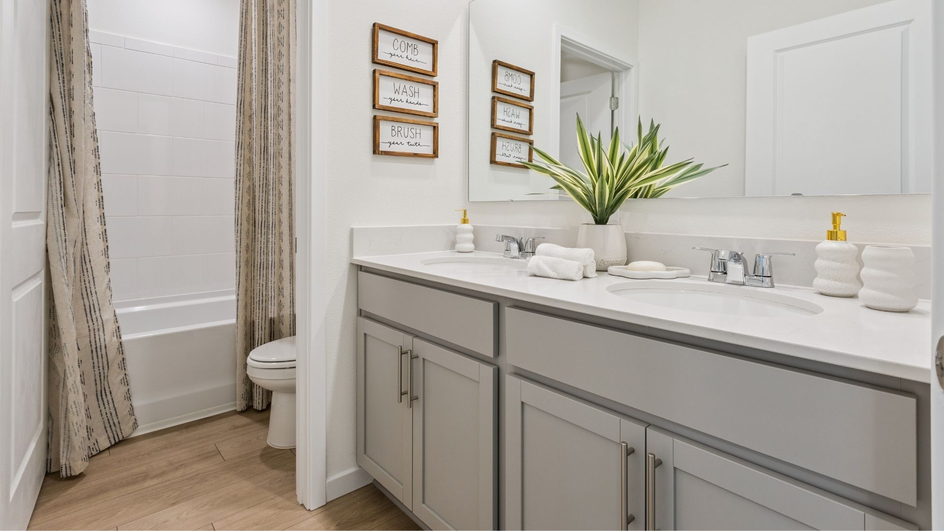 Modern bathroom with single vanity, large wall mirror, cabinets and quartz countertops