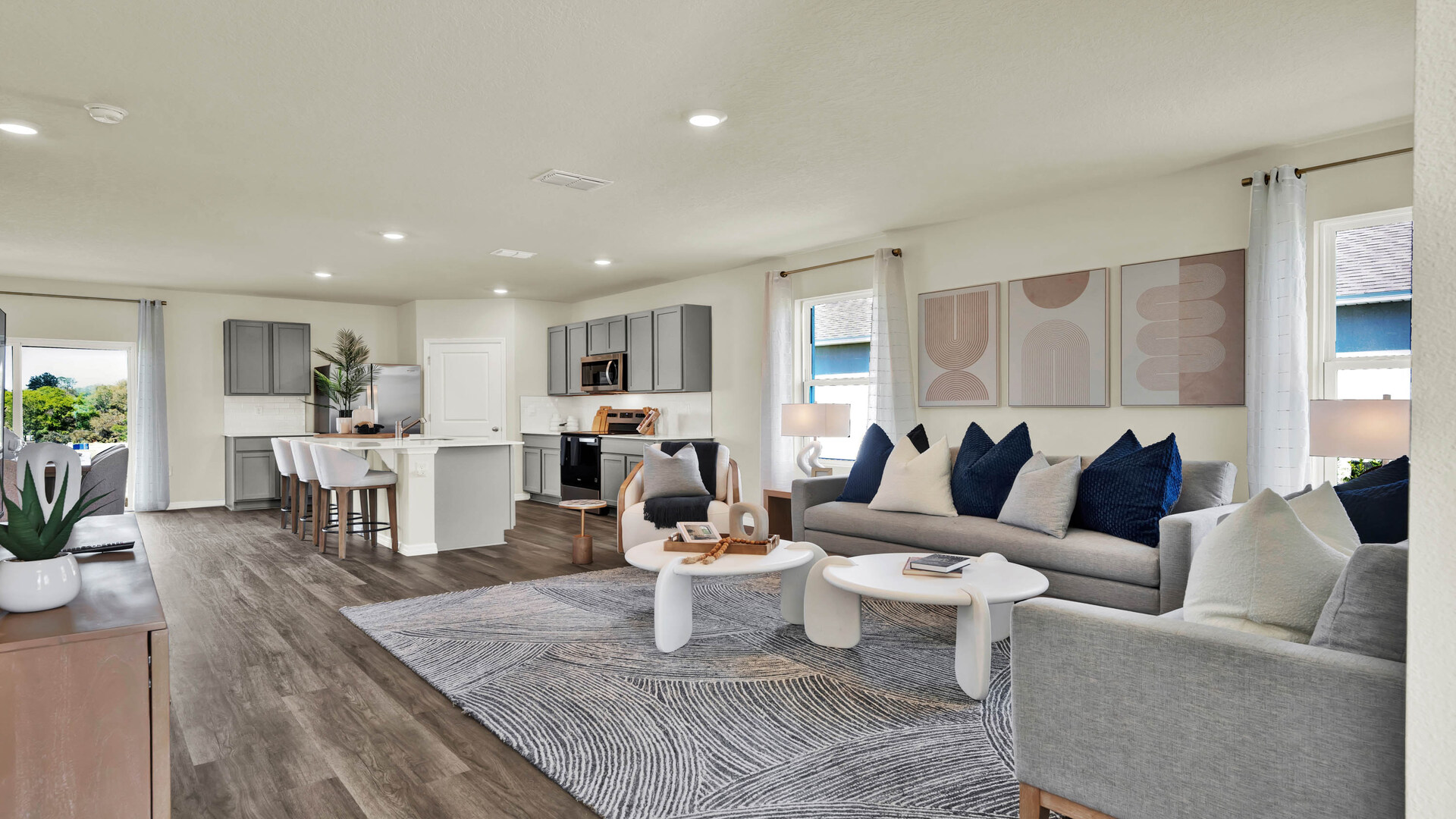 Living area with couch seating overseeing kitchen and dining room with luxury vinyl plank flooring.