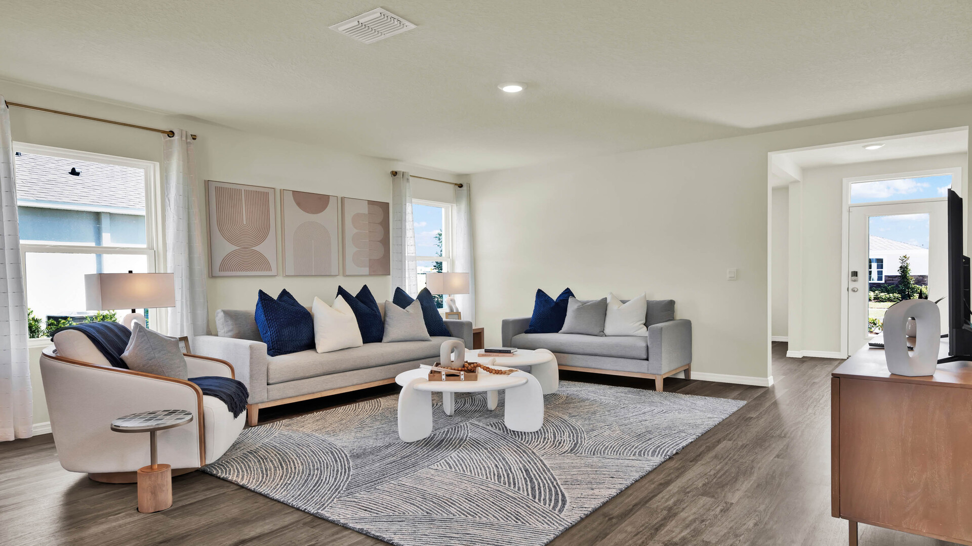Living area with couch seating overseeing kitchen and dining room with luxury vinyl plank flooring.