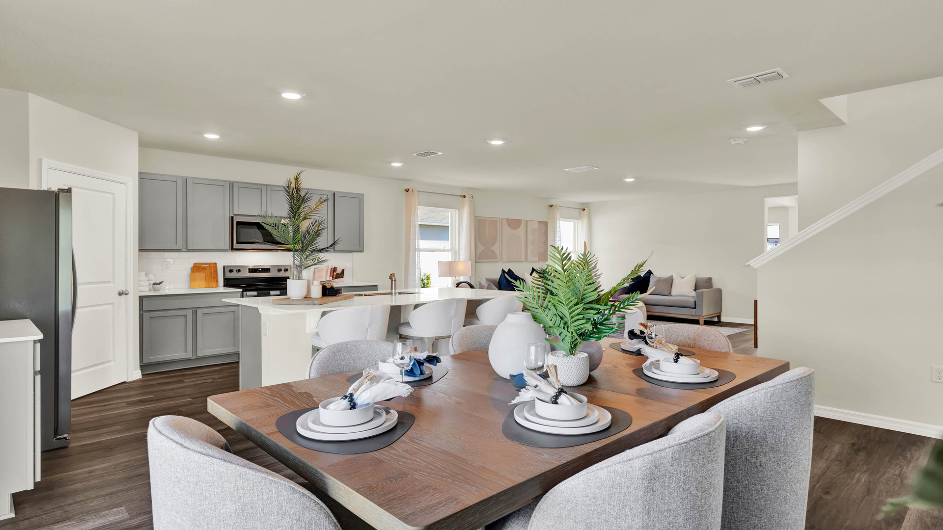 Dining room table by kitchen island with luxury vinyl plank flooring.